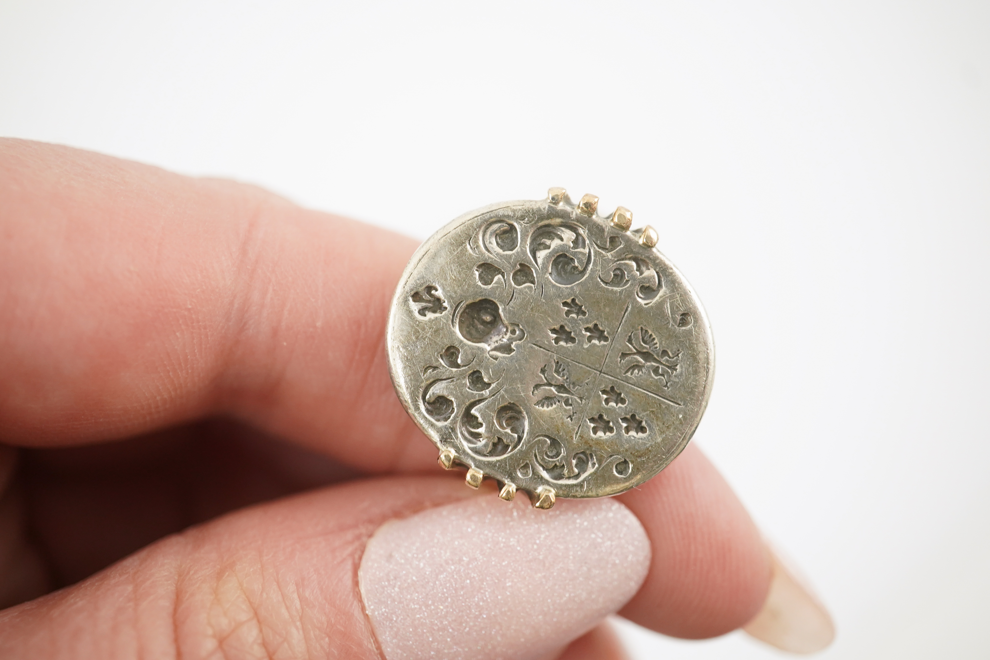 An early 18th century silver and gold signet ring, embossed with an armorial, size R, together with a steel double ended fob seal